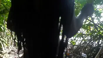 Naked skinny tribe woman making a bow to go hunting