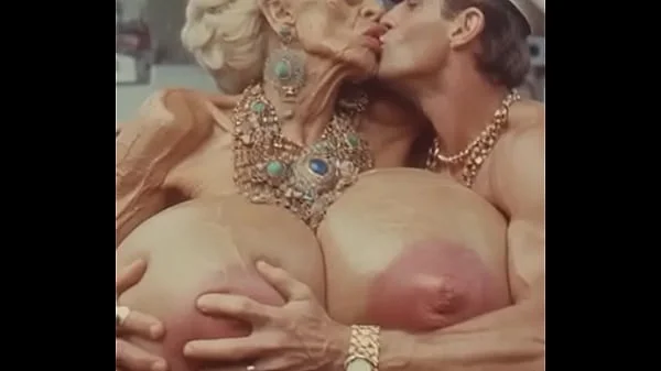 JAY7 Granny Boob Cruise 01 - AI VIDEO - A topless and horny granny with huge bolt-on tits gives a crazy titjob to the skipper