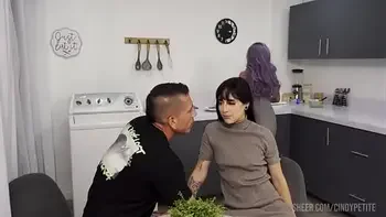 He fucks his coworker while his wife prepares lunch for them.