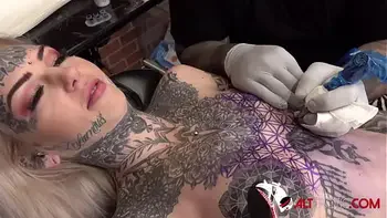Sascha plays with Amber Luke while she gets tattooed