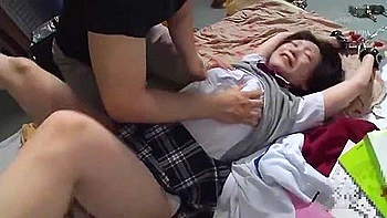 She is attacked by a man who is fondling her large breasts and has her hands and feet tied up.