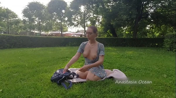 Woman relaxing in park. Flashing beautiful tits