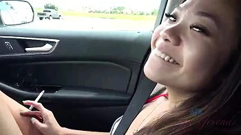 Chica asiática fuma, mea y juega con juguetes en coche