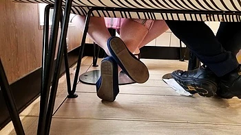 Babe mit blauen Flats spielt mit ihren Füßen
