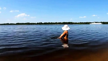 Rubia nudista muestra tatuajes sola en el río