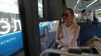 A girl rides a public bus with bare breasts
